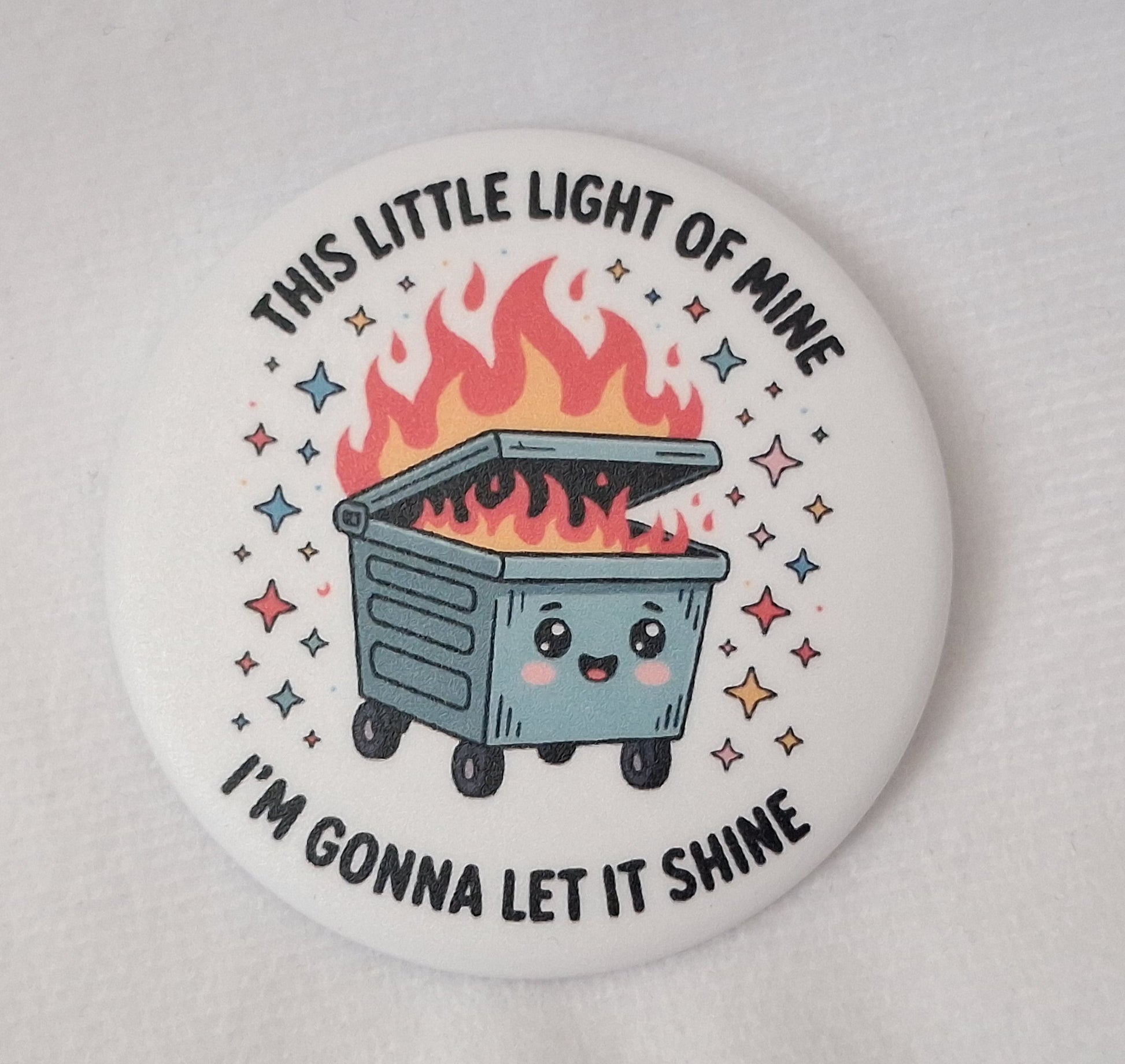 Button badge with a cartoon dumpster fire and text on a white background.