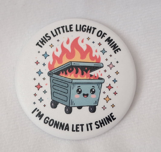 Button badge with a cartoon dumpster fire and text on a white background.